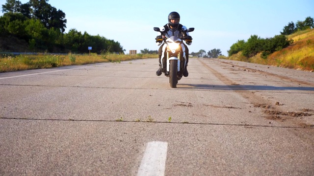 戴头盔的男子在高速公路上驾驶强大的运动摩托车。摩托车在乡间柏油路上超速行驶。穿着防护装备享受速度的家伙。自由的概念。慢动作视频素材