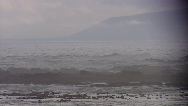 海浪滚到岩石沙滩上。视频素材