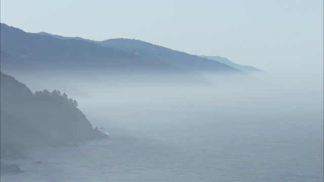 一层雾遮住了多山的海岸线。视频素材