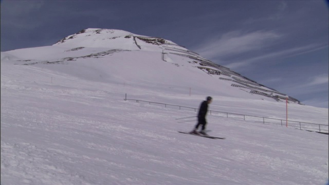 两个滑雪者滑下山坡。视频素材