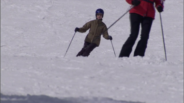 一位妇女平稳地回转滑下滑雪坡。视频素材