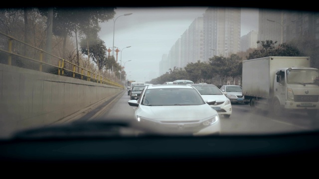 女子在高速公路上行驶，从汽车后窗观看视频素材