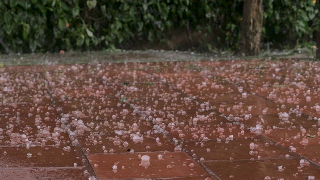 在暴风雨期间冰雹石头击中瓷砖的特写视频素材