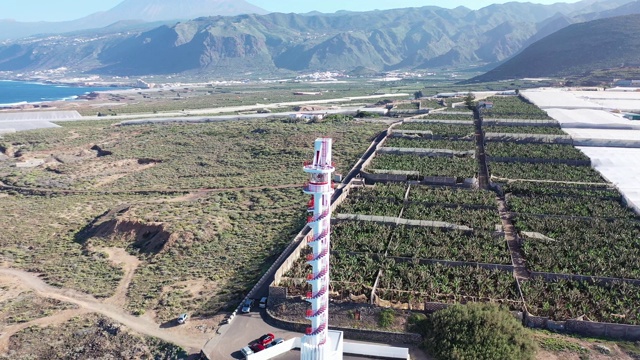 在特内里费岛，用无人机鸟瞰海边的一座红白灯塔视频素材