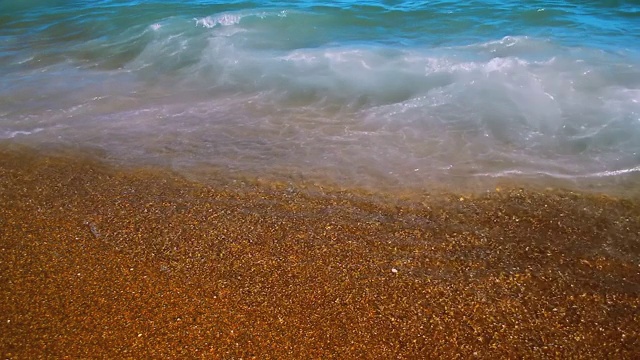 炎炎夏日，海浪掠过，沙滩上的金沙融化。视频素材