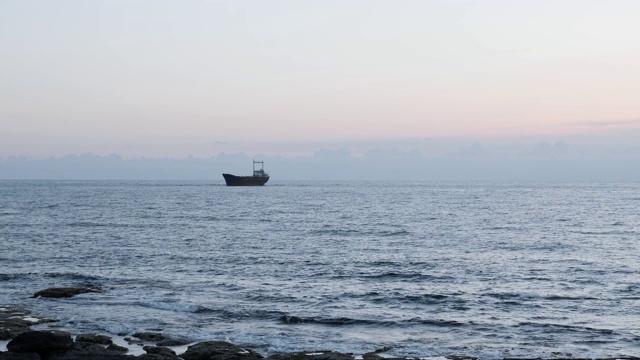 海景与老生锈的船的背景。一艘生锈的大船搁浅在多岩石的岸边。美丽的海景在雨天。生锈的货船在海上搁浅。货船靠近岩岸视频素材