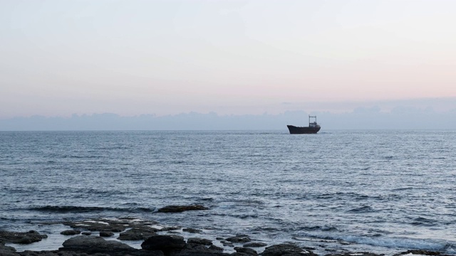 生锈的旧船搁浅在海上。美丽的海景。海与旧船搁浅。美丽的海景在雨天。一艘大船停泊在多岩石的海岸附近。视频素材