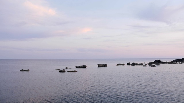 早日落与多云的天空在地中海。黄昏时海面平静。夜幕降临，平静的大海和天空一片漆黑。美丽的海洋背景视频素材