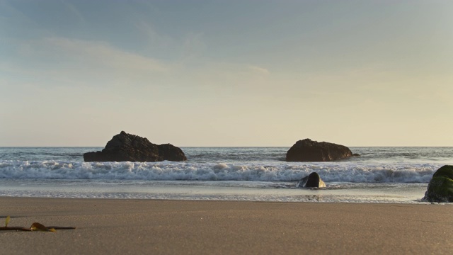 海浪拍打着岩石拍打着沙滩视频素材