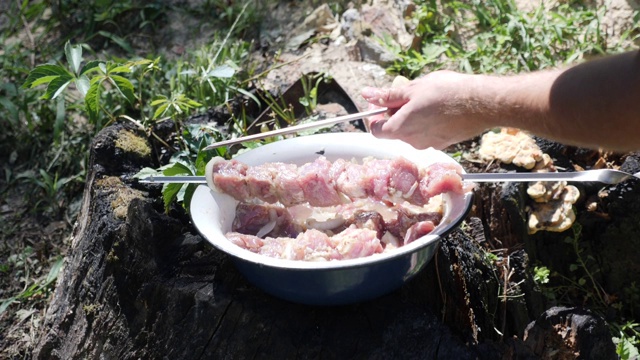 男人准备炸肉的特写。生肉串在串上。用洋葱腌料烹制烤肉视频素材