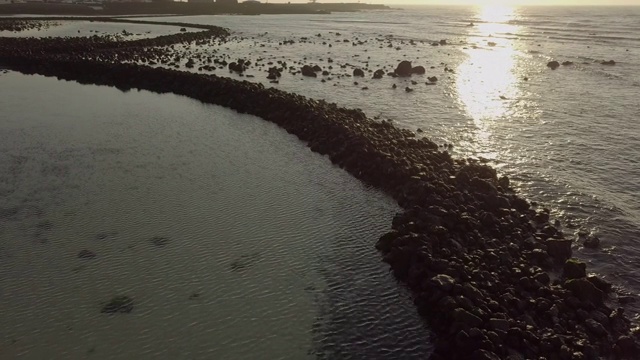 韩国济州岛金陵海滩/济州岛西的捕鱼石墙日落风景视频素材