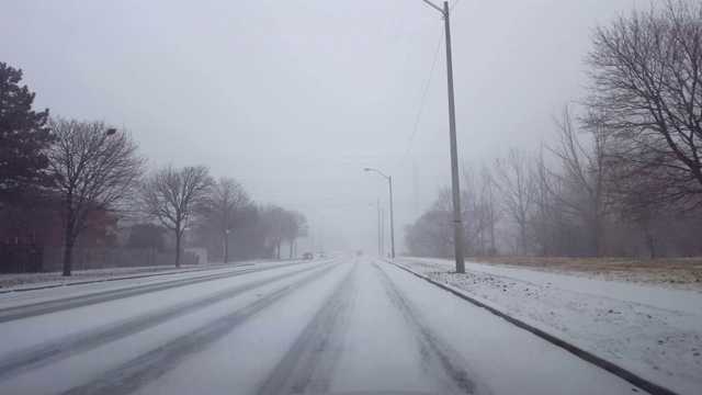 驾驶冬季暴风雪与车辆交通在白天。司机观点POV下雪暴风雪下雪天气条件与许多汽车在道路上。视频素材