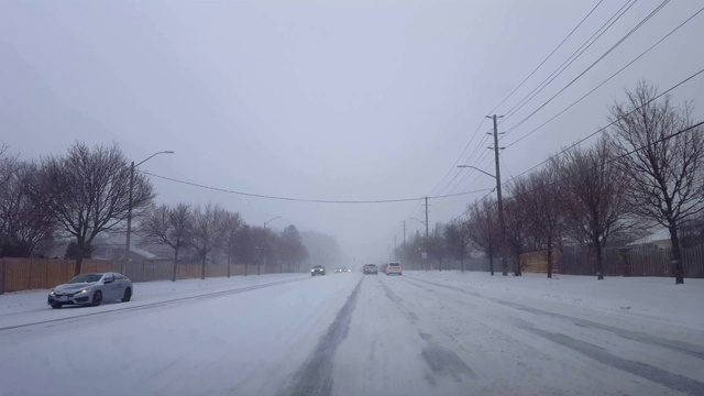 *明亮版本*驾驶冬季暴风雪与车辆交通在天。司机观点POV下雪暴风雪下雪天气条件与许多汽车在道路上。视频素材