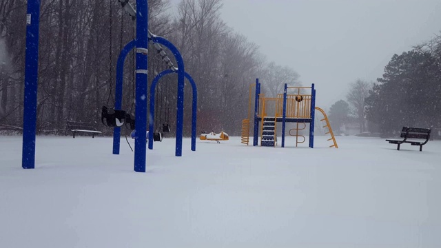 *明亮版本*儿童游戏公园在冬天下雪。操场上白天下雪，地上有雪。视频素材