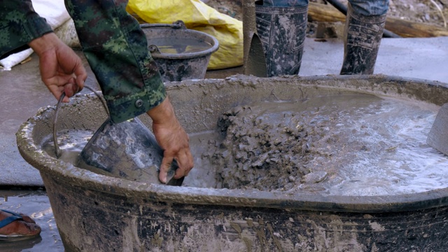 工人在建筑工地搅拌水泥。视频素材