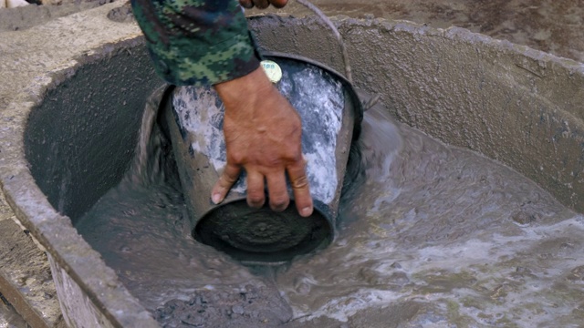 工人在建筑工地搅拌水泥。视频素材