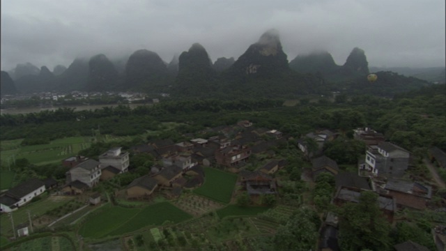 雾部分覆盖了中国一个村庄附近的山脉山峰。视频素材