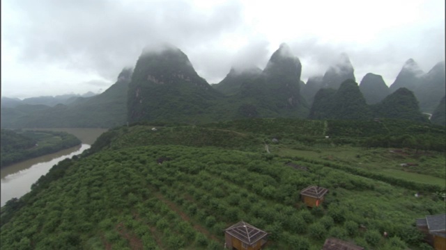 在中国，浓雾笼罩着郁郁葱葱的山脉和农田。视频素材