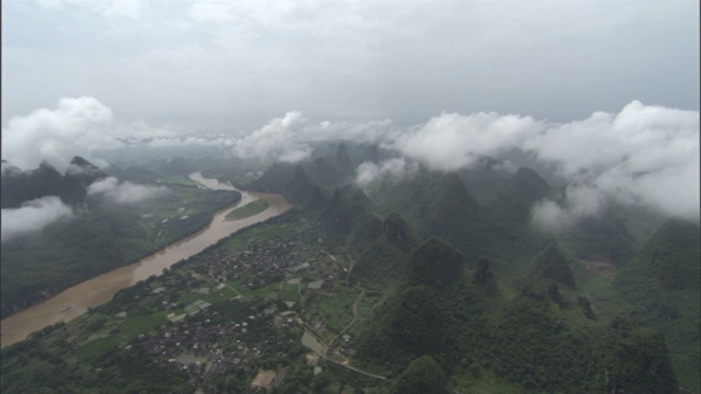 云在中国南方龙神河沿岸的一个村庄附近的山峰上。视频素材