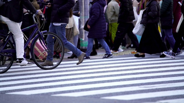 慢镜头城市景观和城市生活的亚洲拥挤的行人，男人和女人与游客步行穿过涩谷十字路口的红绿灯人行横道，东京市，日本视频素材