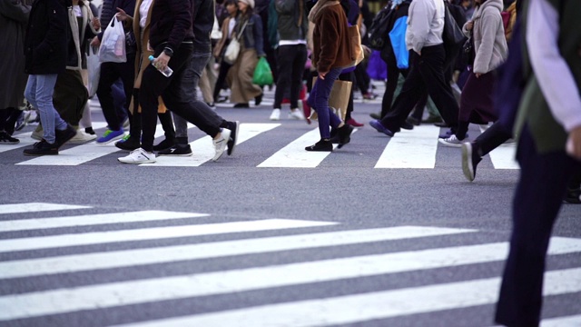 慢镜头城市景观和城市生活的亚洲拥挤的行人，男人和女人与游客步行穿过涩谷十字路口的红绿灯人行横道，东京市，日本视频素材