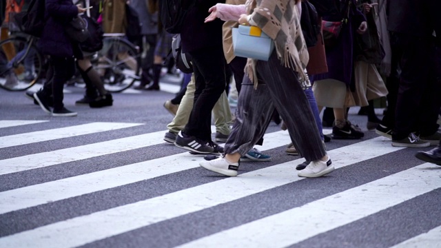 慢镜头城市景观和城市生活的亚洲拥挤的行人，男人和女人与游客步行穿过涩谷十字路口的红绿灯人行横道，东京市，日本视频素材