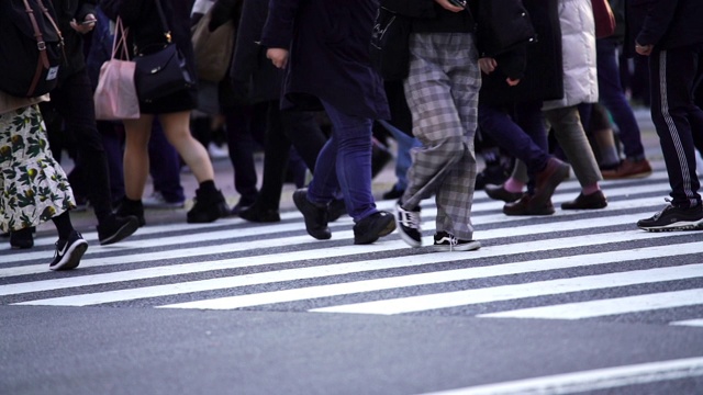 慢镜头城市景观和城市生活的亚洲拥挤的行人，男人和女人与游客步行穿过涩谷十字路口的红绿灯人行横道，东京市，日本视频素材