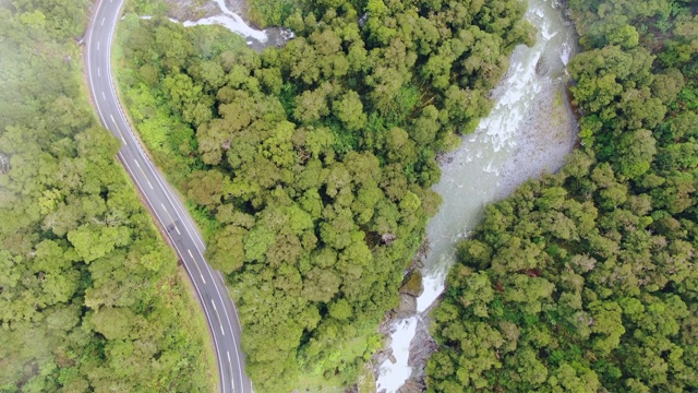 鸟瞰无人机飞行上方雾蒙蒙的哈斯特山口公路和哈斯特河，奥塔哥地区和西海岸之间的山区在新西兰南岛的南阿尔卑斯山。视频素材