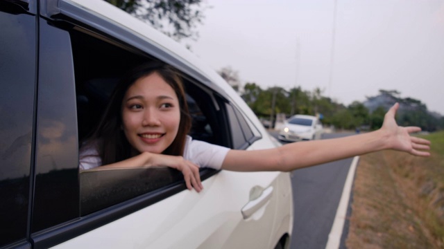 掀背车旅行驾车公路旅行的年轻女子暑假在汽车在假日日落和放松得到的气氛和去目的地。慢动作C4K电影镜头视频素材