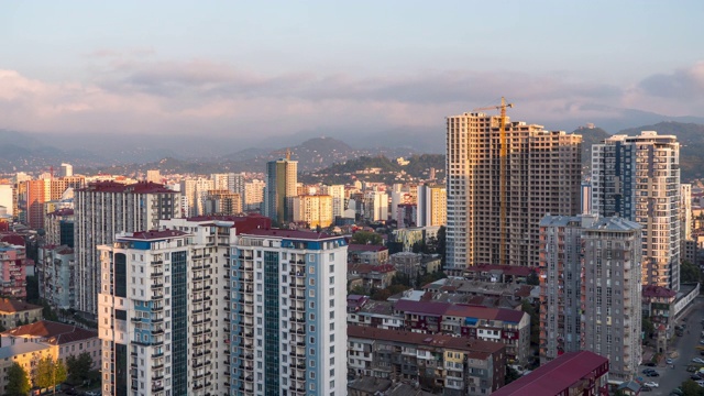 有建筑工地、摩天大楼、交通和山脉的城市空间。间隔拍摄。巴统,格鲁吉亚视频素材