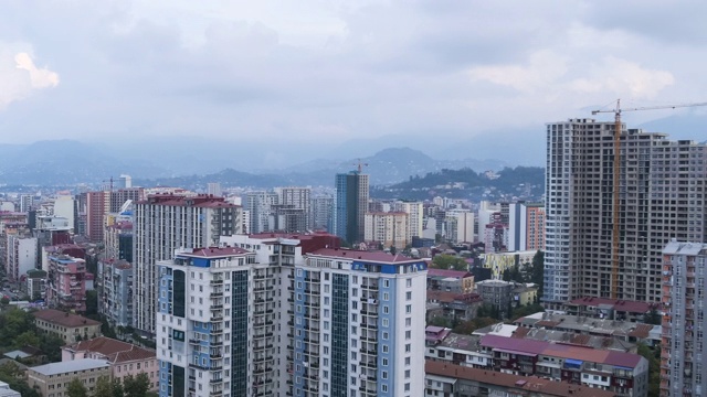 有建筑工地、摩天大楼、交通和山脉的城市空间。间隔拍摄。巴统,格鲁吉亚视频素材