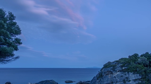 小岩石海滩上的晚霞。时间流逝视频素材