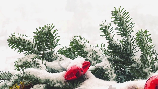 圣诞树的树枝上装饰着雪下的玩具。视频素材