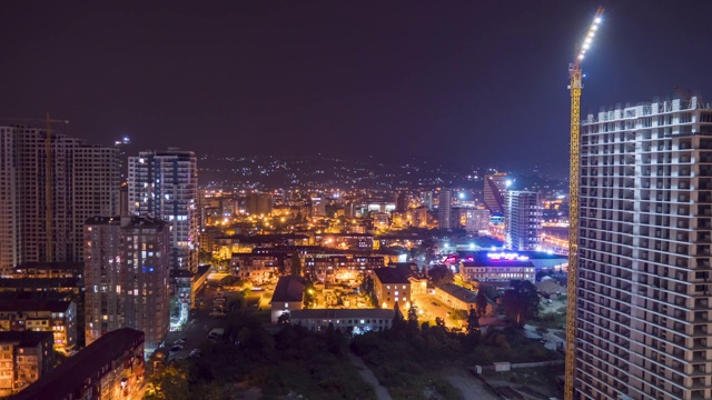 一个有摩天大楼和建筑物的大城市的夜间建筑工地。间隔拍摄视频素材