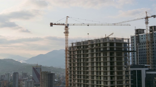 建筑工地上的塔式起重机在高层建筑中吊装重物。间隔拍摄。建筑施工视频素材