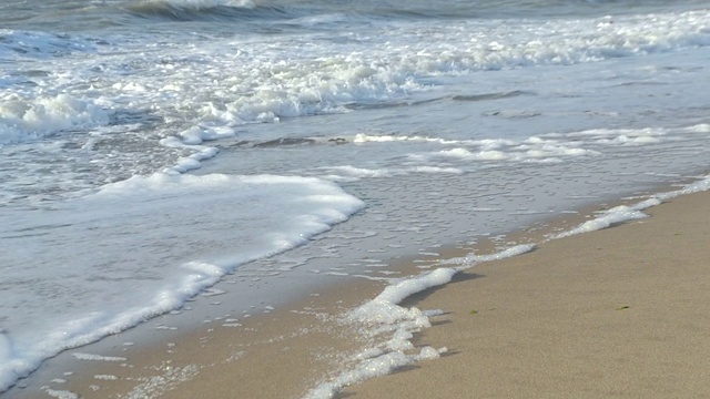 水面的海水海浪与白色泡沫近距离沙滩。视频素材