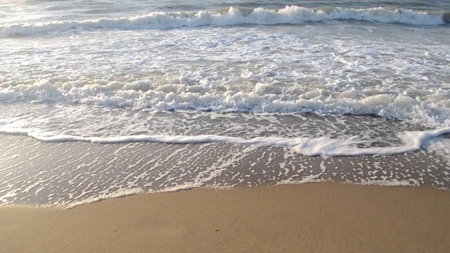 水面的海水海浪与白色泡沫近距离沙滩。视频素材