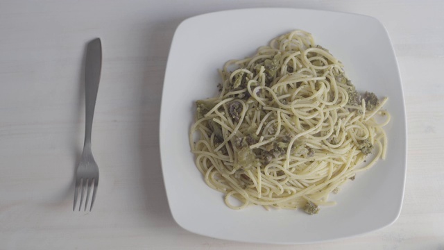 一个意大利女人的手的特写，以正确的方式卷素食意大利面与西兰花和橄榄油，在工作室与热气腾腾的菜- 4k程序3未分级的食物镜头视频素材