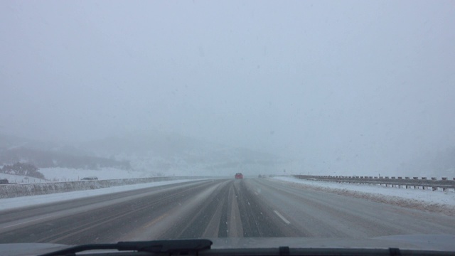 POV:在一个极端的暴风雪期间，在一条冰雪覆盖的州际高速公路上行驶视频素材