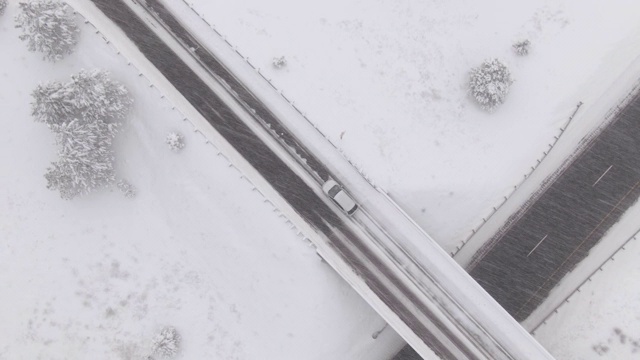 从上到下:飞过一辆汽车，行驶在雪桥上，穿越空无一人的高速公路。视频素材