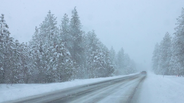 在斯波坎市，人们在暴风雪中驾车行驶在一条下雪的乡村道路上。视频素材