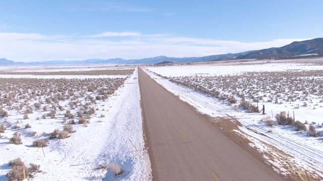 无人机:在一个阳光明媚的冬日里，游客们乘坐SUV探索犹他州的雪地平原视频素材