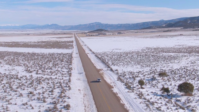 图片:风景优美的沥青公路引导着银色的SUV穿过雪景。视频素材