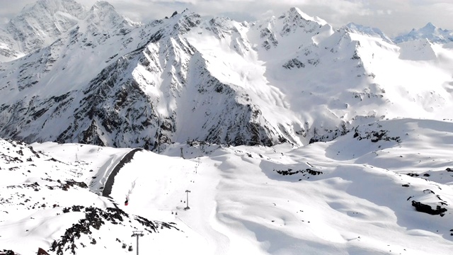 鸟瞰图的缆车和滑雪坡道在高加索的高山在度假胜地厄尔布鲁斯在冬季。垂直全景视频素材