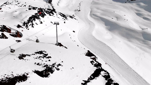 鸟瞰图的缆车和滑雪坡道在高加索的高山在度假胜地厄尔布鲁斯在冬季。跟踪小屋索道视频素材