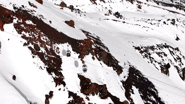 鸟瞰图的缆车和滑雪坡道在高加索的高山在度假胜地厄尔布鲁斯在冬季。跟踪小屋索道视频素材