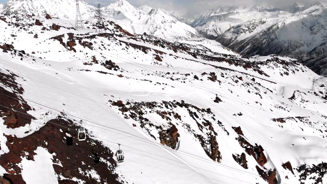 鸟瞰图的缆车和滑雪坡道在高加索的高山在度假胜地厄尔布鲁斯在冬季。跟踪小屋索道视频素材