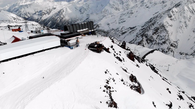 鸟瞰图站滑雪缆车与小屋高在高加索山脉在度假胜地厄尔布鲁斯在冬季。车站及索道概况视频素材