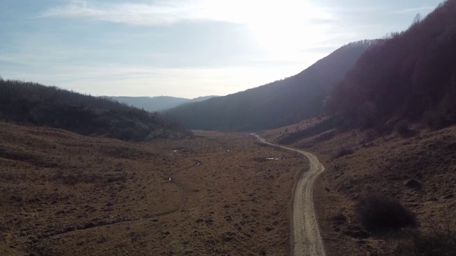 无人机拍摄的乡村地区有山丘和枯死的植被在秋天的白天视频下载