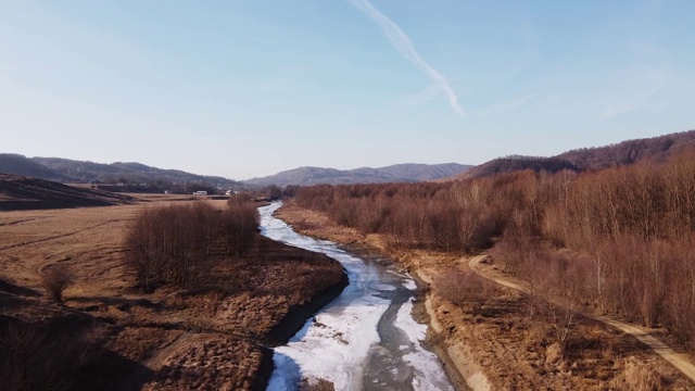 无人机拍摄的是深秋的森林和乡村冰冷的河流。深秋的森林山丘。鸟瞰图森林。视频素材